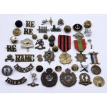 A collection of military badges and buttons along with a French medal and one other