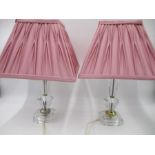 A pair of cut glass lamps with pink shades