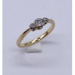 An unmarked 18ct gold diamond three stone ring