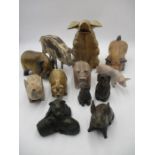 An assortment of resin, metal and wooden pig ornaments.