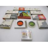 A collection of camera lens filters including Hoya and Vivitar along with an 8mm home movie "Genghis