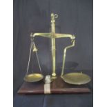 A set of brass Avery scales mounted on oak plinth