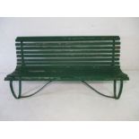 A green painted garden bench with metal supports