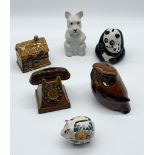 A collection of ceramic money boxes including Wade, Szeiler etc.