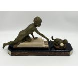 A French Art Deco gold patinated spelter figure of a girl playing with a cat holding an ivorine