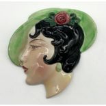 A ceramic Art Deco wall plaque by Cope and Co. depicting a lady in green hat. 16.5cm x 17cm.