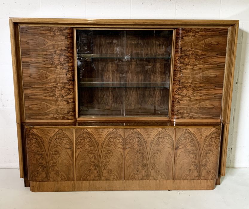 An Art Deco burr walnut bookcase with sliding glass doors and multiple cupboards