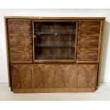 An Art Deco burr walnut bookcase with sliding glass doors and multiple cupboards