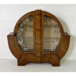An Art Deco walnut veneered circular display cabinet enclosing two shelves and silk-lined back.