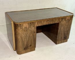 An Art Deco figured walnut desk with rounded rectangular writing surface with twin panelled doors