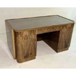 An Art Deco figured walnut desk with rounded rectangular writing surface with twin panelled doors