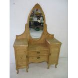 A pine dressing table with two drawers flanked by cupboards