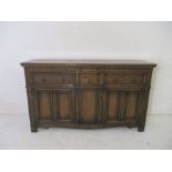 Large oak sideboard with carved decoration and panelled doors, length 183cm.