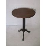 A Victorian round table on cast iron tripod stand.