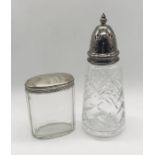 A silver topped sugar caster along with a silver topped dressing table pot