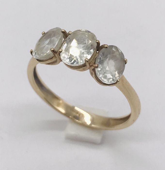 A 9ct gold three stone ring set with white topaz