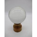A vintage crystal ball on wooden stand approx. 12cm diameter