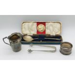 A small hallmarked silver jug, silver Coronation spoon and napkin ring along with a pair of silver