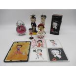 A collection of Betty Boop items including small boxed figurines, alarm clock, coasters, trinket