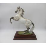 A ceramic Kaiser sculpture of a Horse, signed 'Cy. Gawantka', on a wooden plinth.