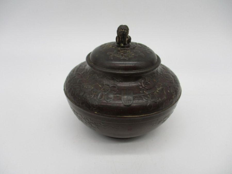 An Oriental bronze tea caddy with inner lid, with embossed decoration.