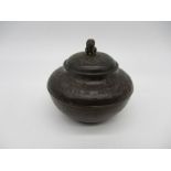 An Oriental bronze tea caddy with inner lid, with embossed decoration.