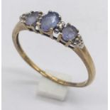 An amethyst three stone ring with small diamonds set in 9ct gold