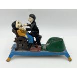 A reproduction cast iron money box in the form of a dentist and patient