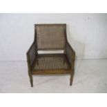 An antique faux bamboo armchair with cane seat