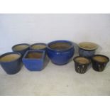 A quantity of blue glazed garden pots of various sizes, largest has crack to bottom.