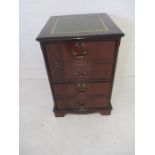 A reproduction filing cabinet with green leather top.