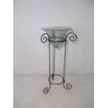 A glass bowl on contemporary wrought iron stand