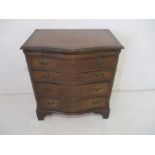 A reproduction serpentine chest of four drawers, with brush slide drawer.