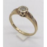 A 9ct gold illusion set diamond solitaire with single diamond to each shoulder