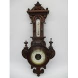 An Edwardian barometer in carved case with thermometer above