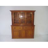 A pine dresser, with glazed doors. Length 156cm, depth 147cm, height 188cm.