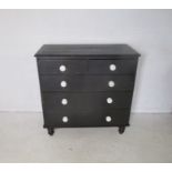 A Victorian ebonised chest of drawers, with original ceramic handles, length 98cm, height 98cm.