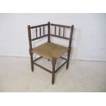 A rush seated bobbin turned oak corner chair.