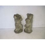 Two reconstituted stone garden ornaments, in the form of pigs playing musical instruments.