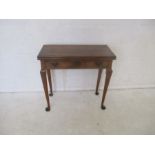 A turn of the century mahogany tea table with single drawer and folding top.