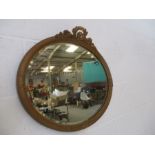 A gilt framed oval mirror.