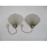 A pair of wall sconces, with scallop shaped glass shades.