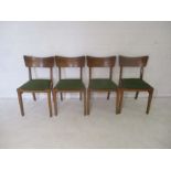 A set of four 20th century oak dining chairs with upholstered seats.