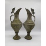 A pair of eastern brass ewers with cobra handles.