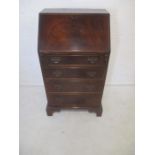 A reproduction narrow mahogany bureau.