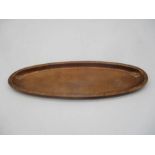 A Hugh Wallis oval copper dish with hammered design, marked H.W.