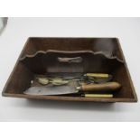 A vintage cutlery tray with an assortment of items.
