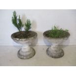 A pair of circular stone garden urns.