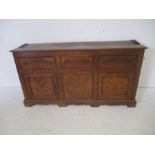 A Georgian oak dresser base, with three drawers and two cupboards, length 183cm, height 86cm.