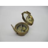 A nautical brass compass, with natural sine table on outer case.